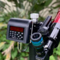 Nexus DSC Pro mounted on a telescope Nexus DSC Pro on a mount with a red telescope. It's set up in a backyard with a leafy green backdrop